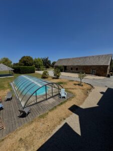 Vue sur piscine et salle de réception avec un beau ciel bleu
